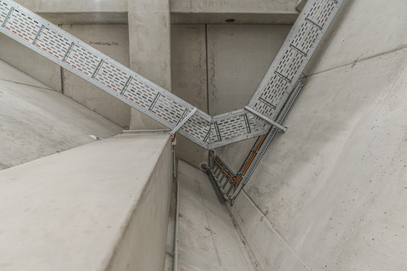 Trassenbau Detailaufnahme von schrägen Betonwänden mit einem Metallgeländer.