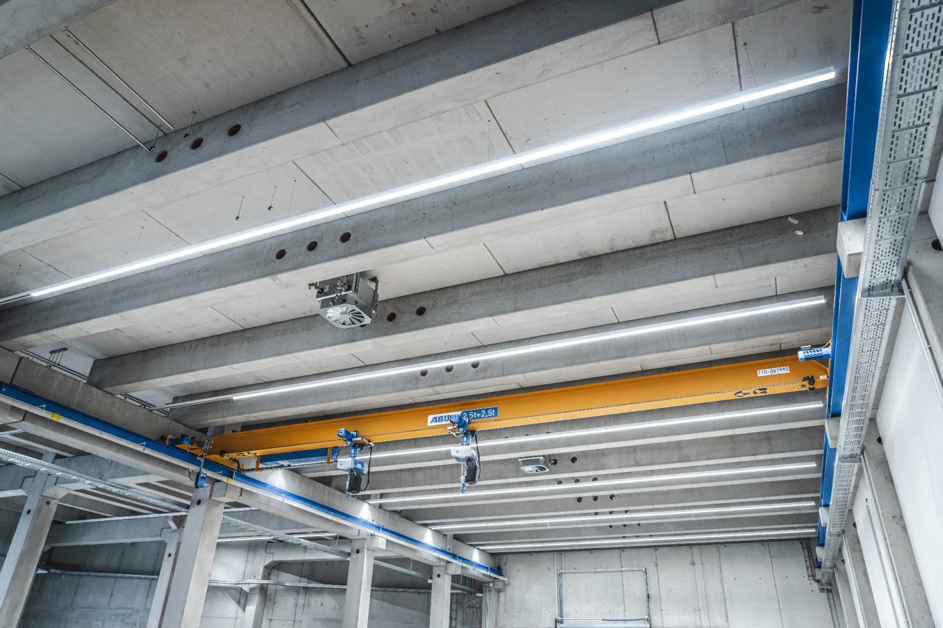 Hallenbeleuchtung Decke eines modernen Industriegebäudes mit Stahlträgern und LED-Beleuchtung.
