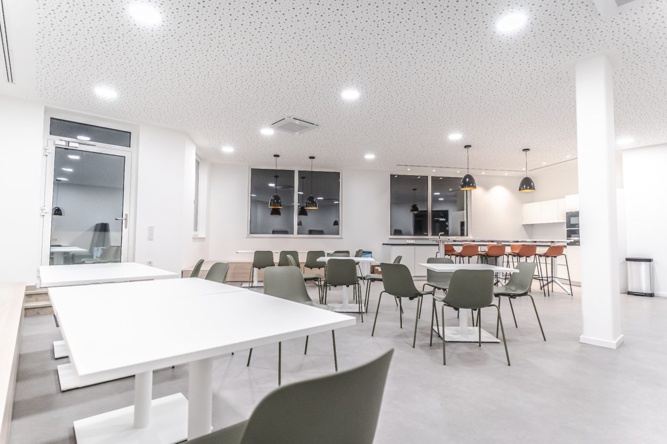 Kantine Moderne, helle Innenansicht eines Essbereichs mit Tischen und Stühlen.